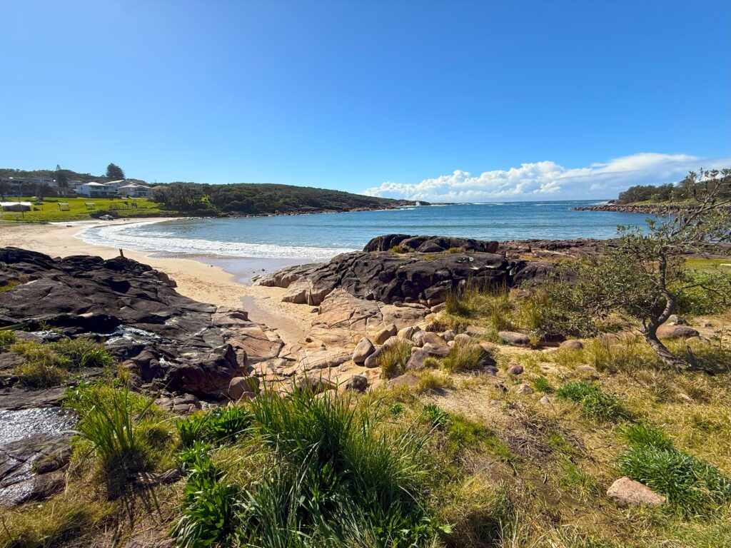 Boat Harbour, Port Stephens showing the sandy beach, boat ramp and rock walls protecting the tranquill bay on a calm sunny day