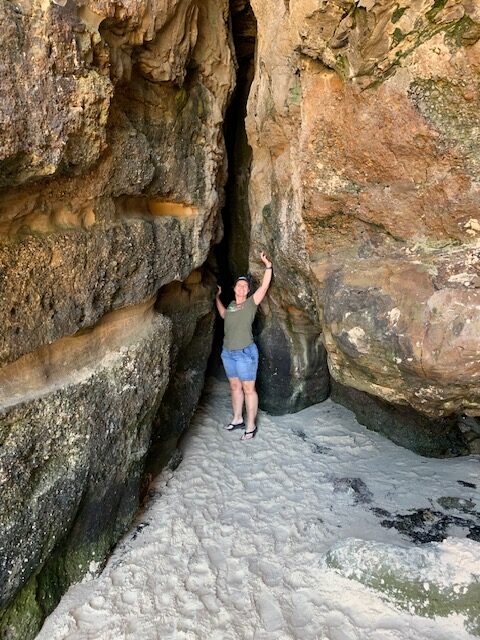 Exploring a chasm in the rocks at Caves Beach