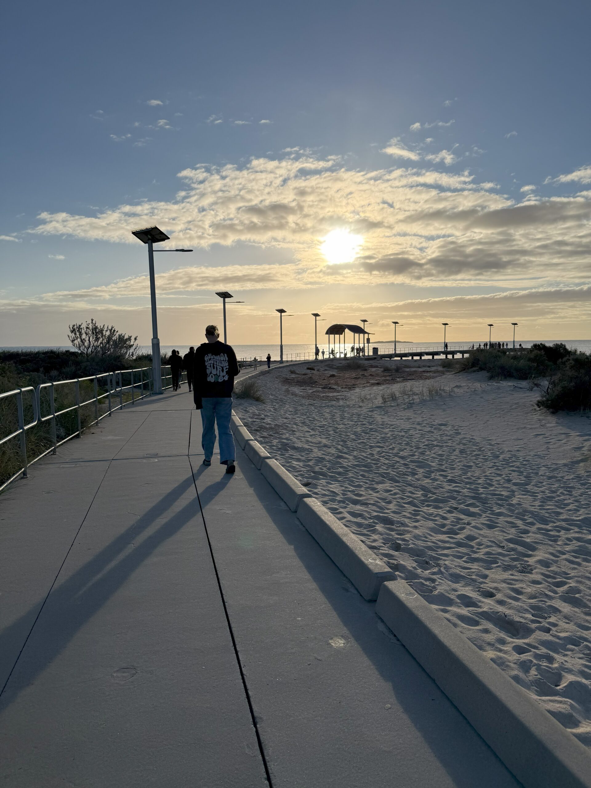 Person walking along Jurien Bay jetty at sunset