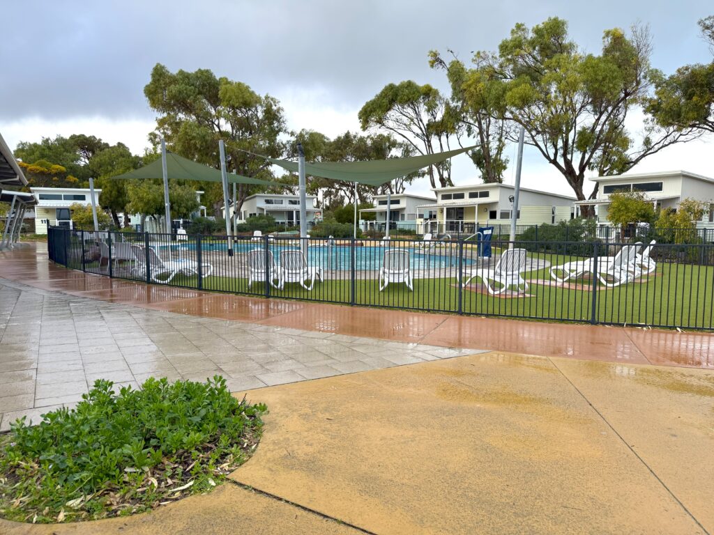 Swimming pool area surrounded by gum trees and villas at RAC Cervantes Holiday Park