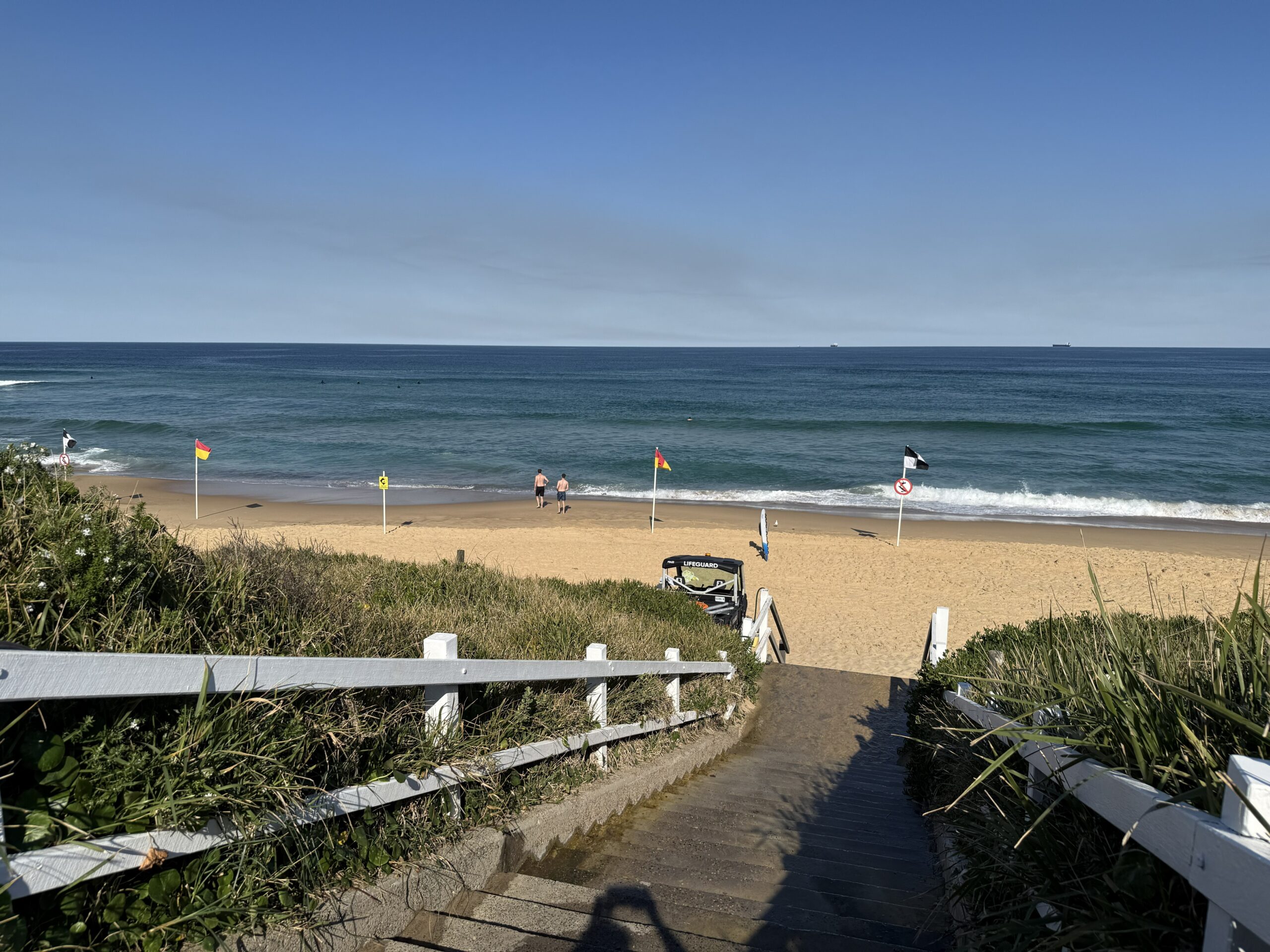 Two people walking along the ANZAC Memorial Walk through the steel diggers lining the path,