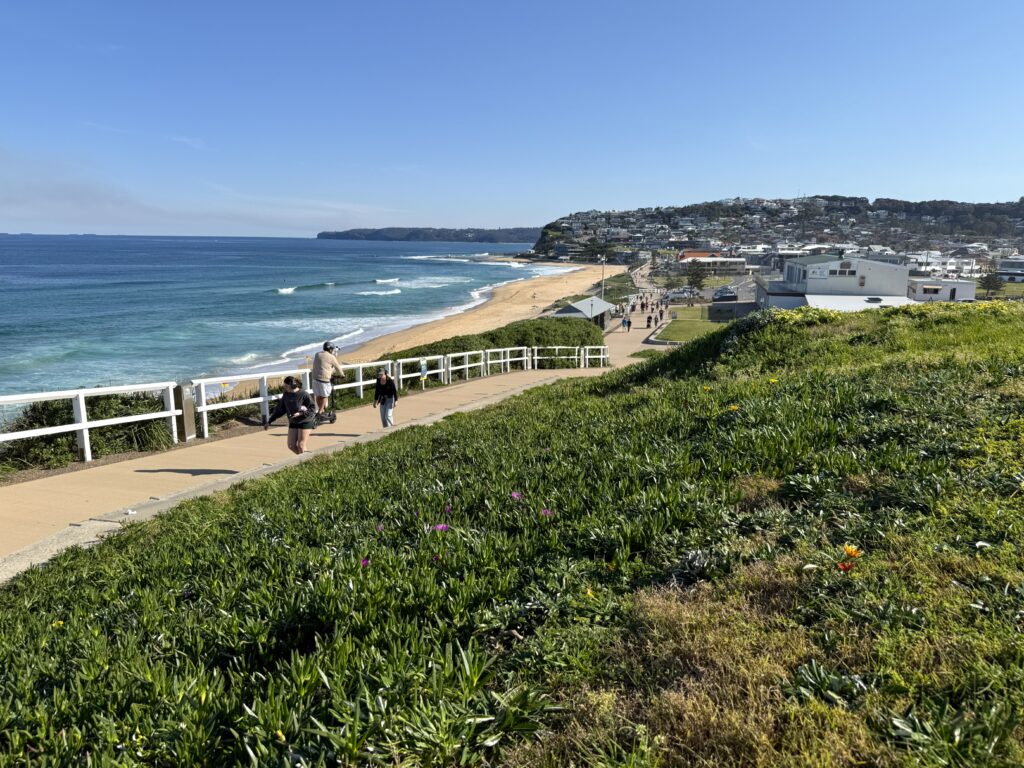People walking along the Bathers Way past Merewether Beach in Newcastle.