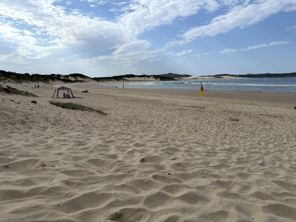 One Mile Beach, Port Stephens on a sunny day with swimming flags and beach cabana