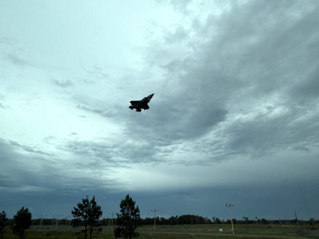 F35A fight jet silhouetted in the sky coming in to land at RAAF Base Williamtown