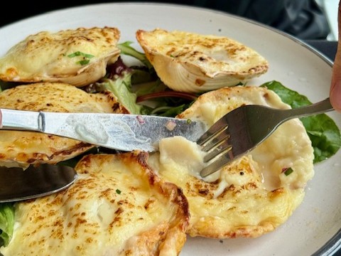 Scallops topped with bechamel sauce and parmesan for entree at the Deck Cafe Restaurant and Bar
