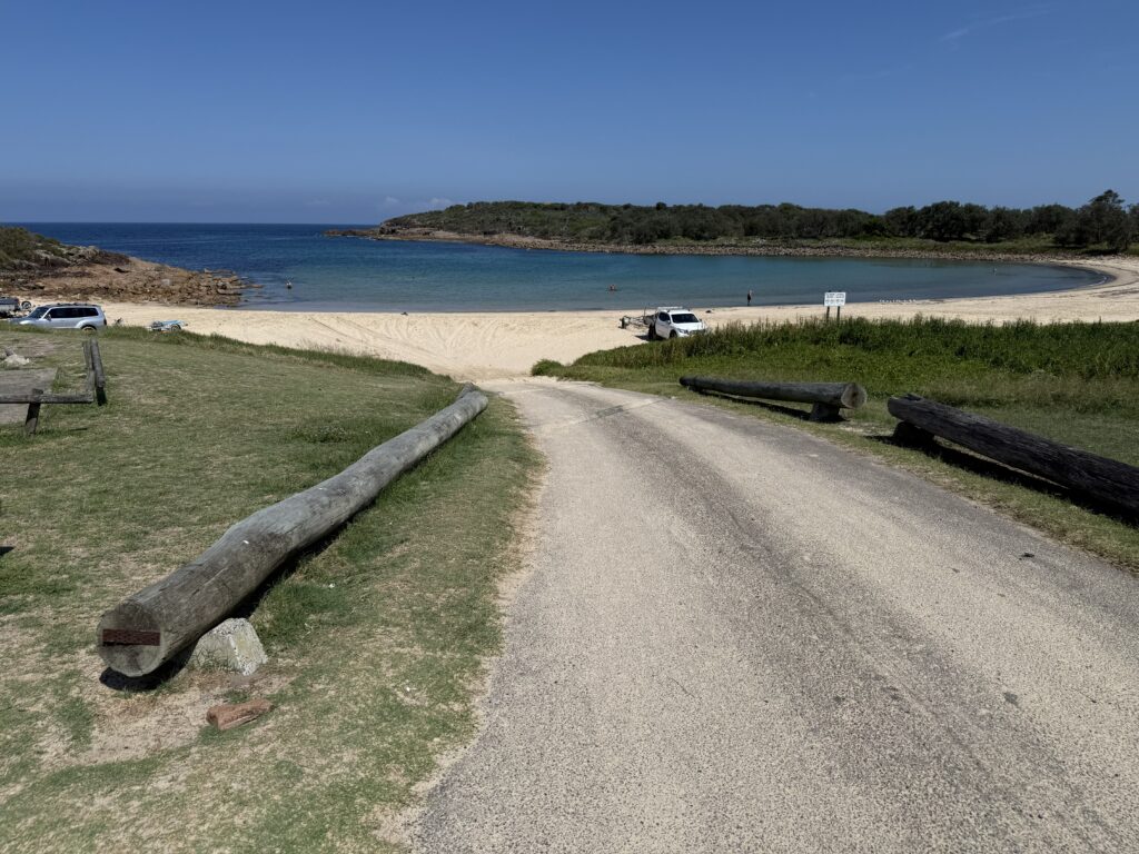 Beach access ramp at Boat Harbour on a calm day with vehicles parked on the beach
