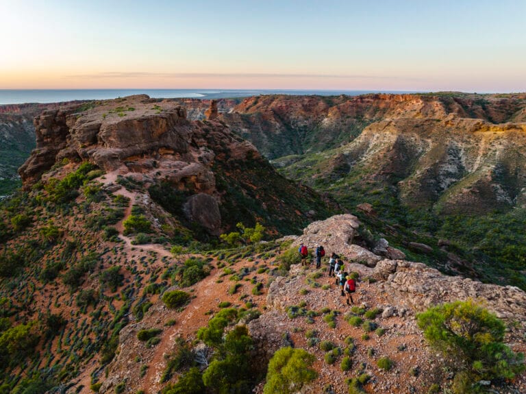 Hikers enjoying an evening stroll along the ridgeline through dramatic limestone gorges at Cape Range National Park