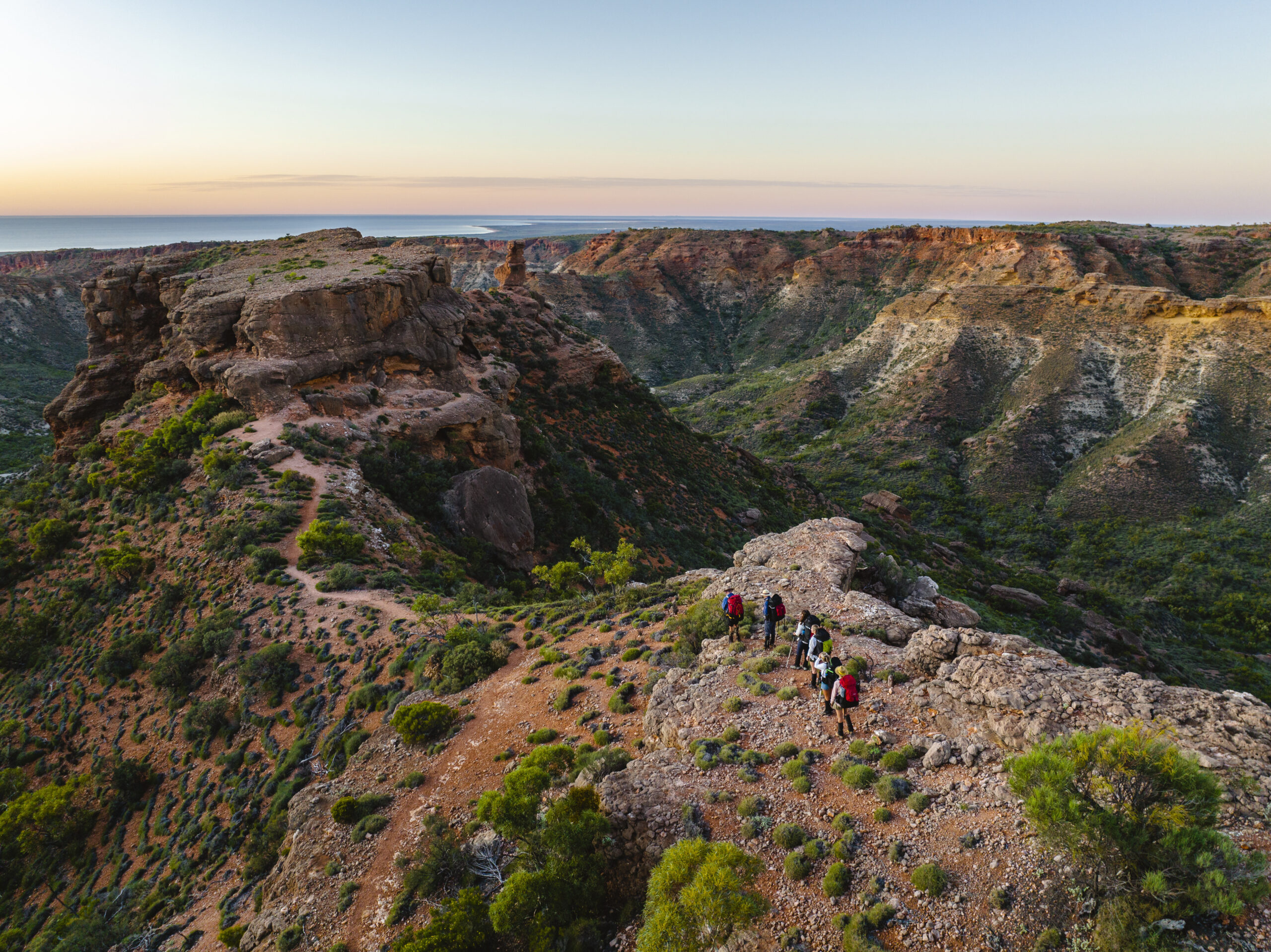 Hikers enjoying an evening stroll along the ridgeline through dramatic limestone gorges at Cape Range National Park