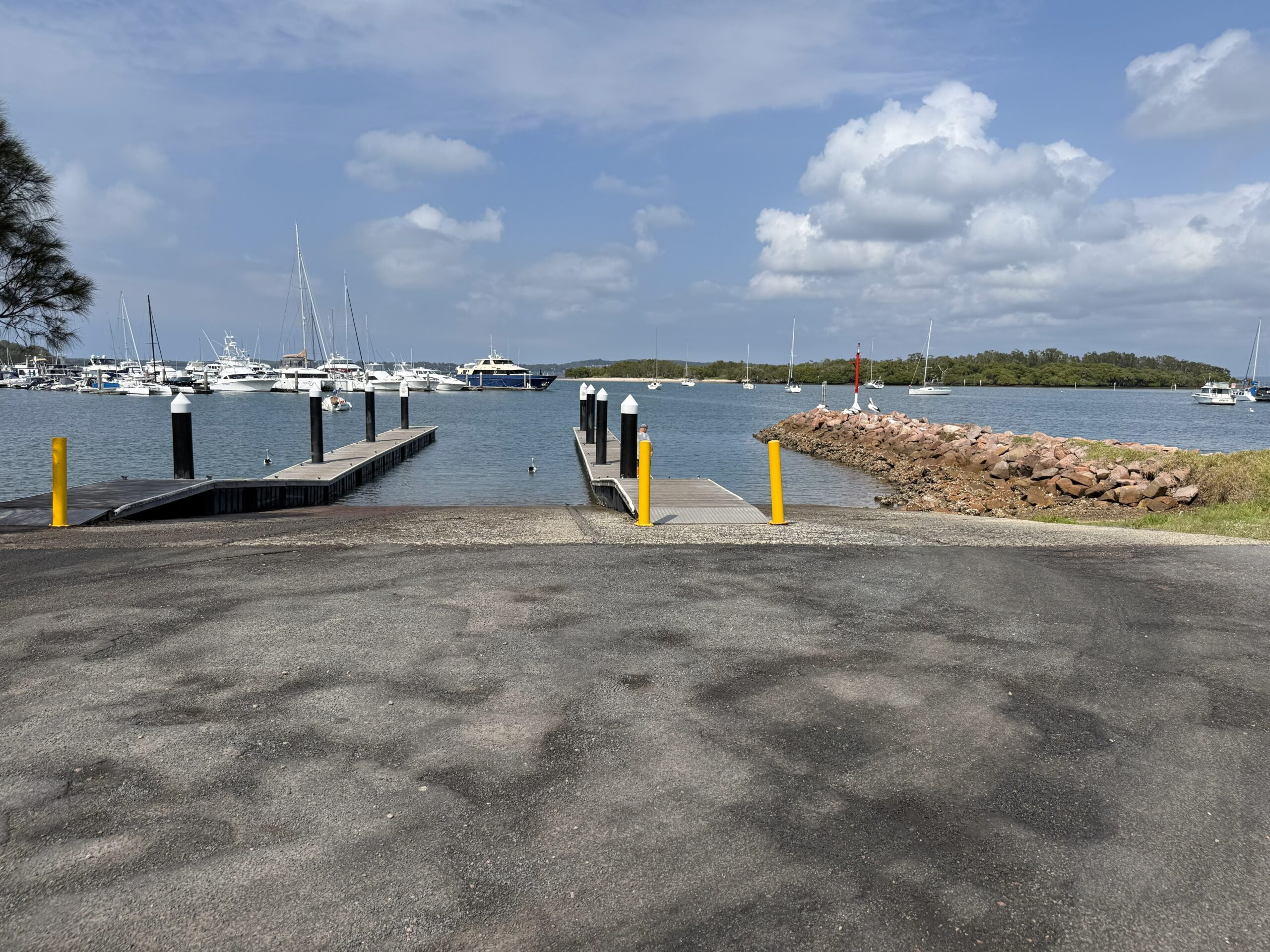 Soldiers Point Boat Ramp showing 3 ramps with floating pontoons and Soldiers Point Marina in the distance