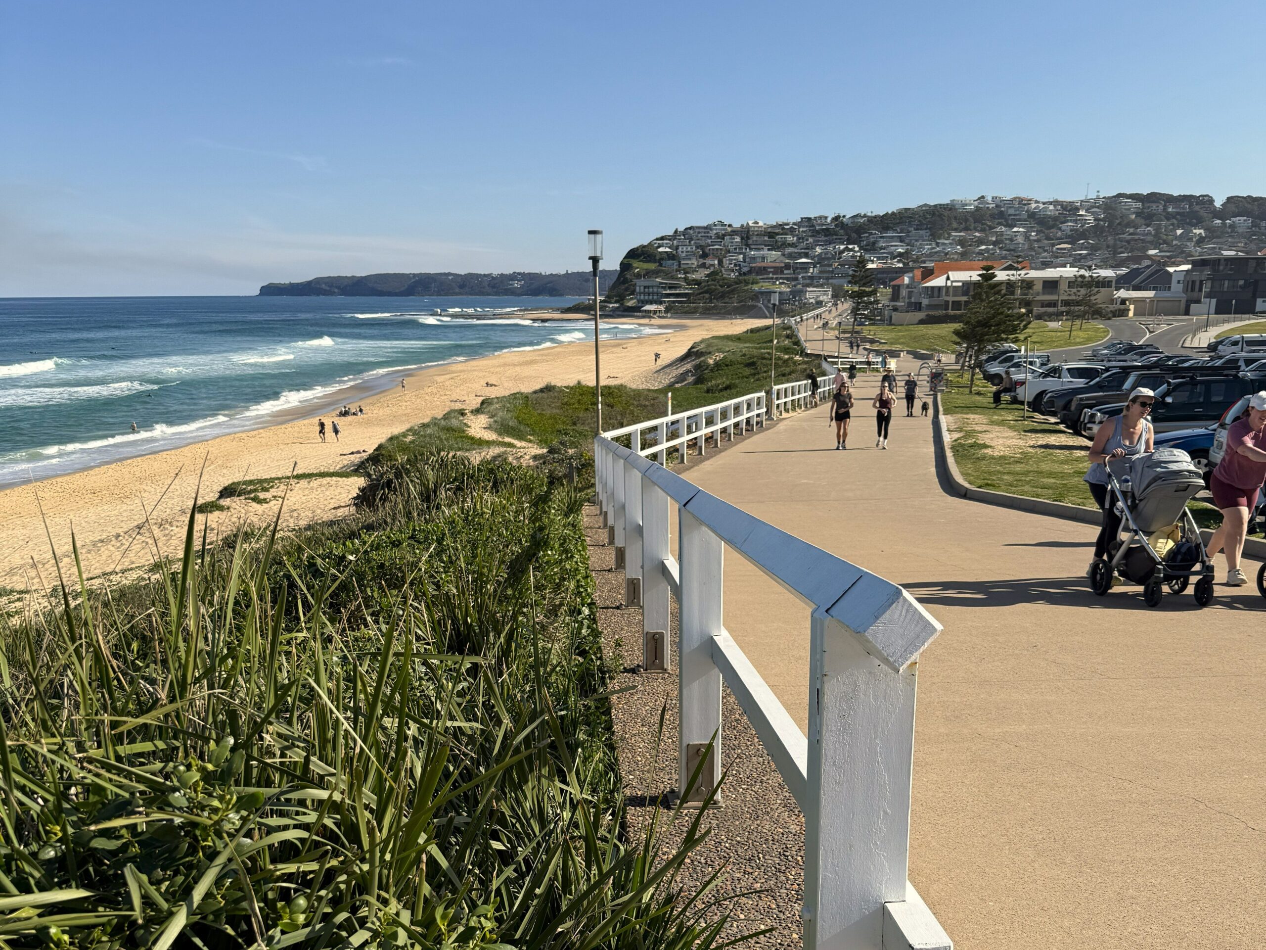 People enjoying a sunny day strolling along the Bather's Way alongside Merewether Beach