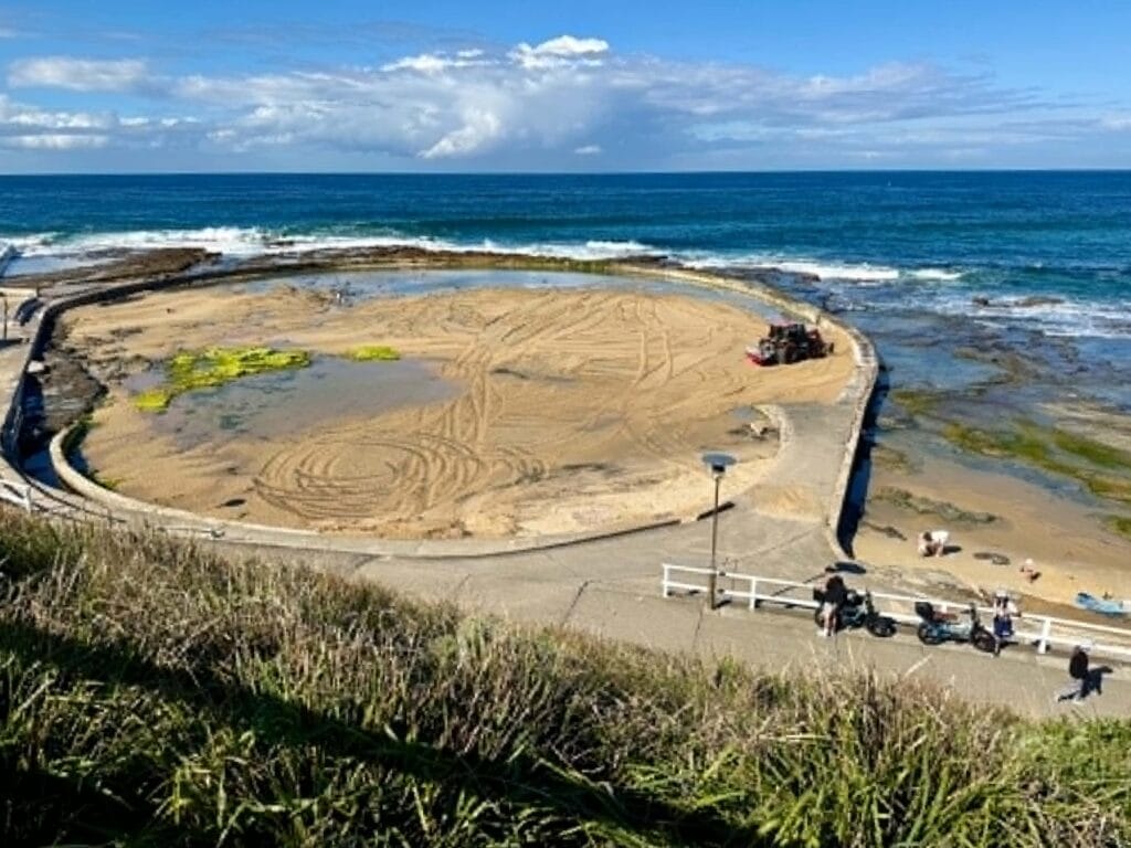 Sand being cleaned out of the Canoe Pool by a tractor