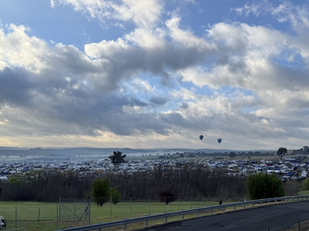 Hot air balloons float over the campgrounds at Mount Panorama