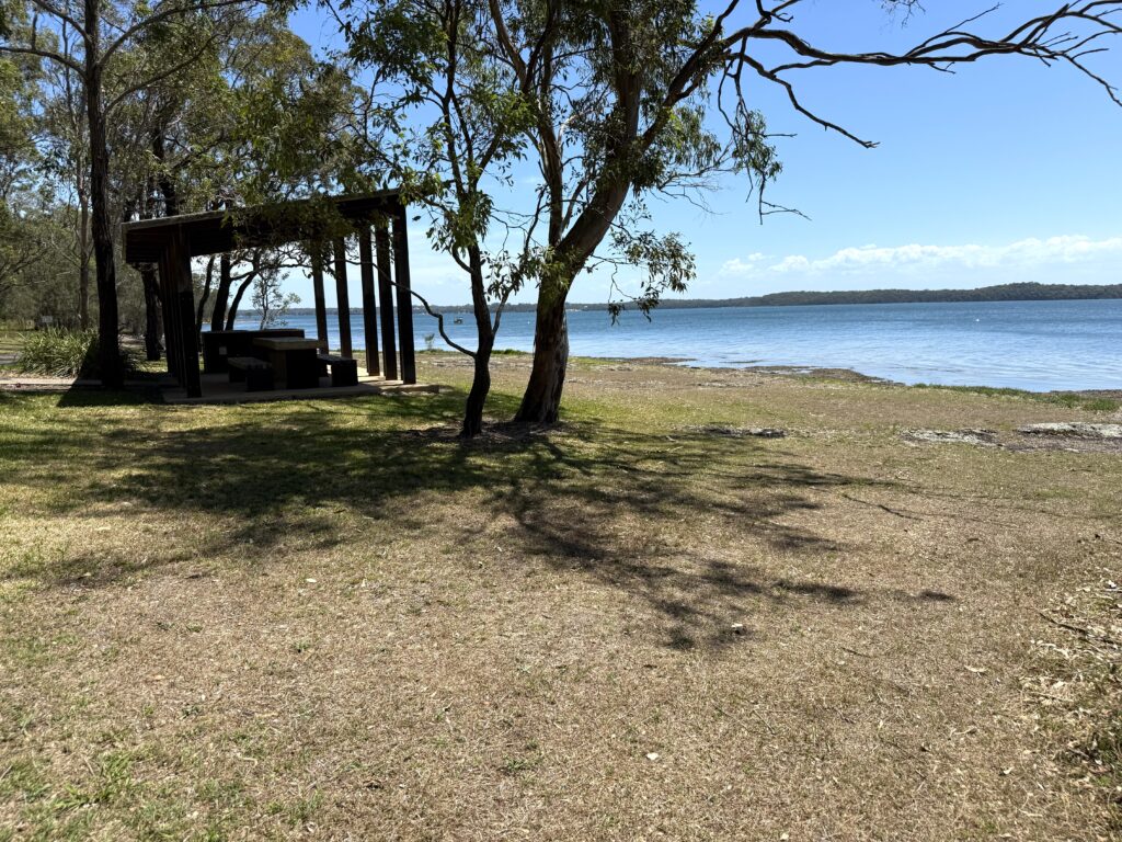Picnic tables in lakeside parklands overlooking Lake Macquarie at Murrays Beach