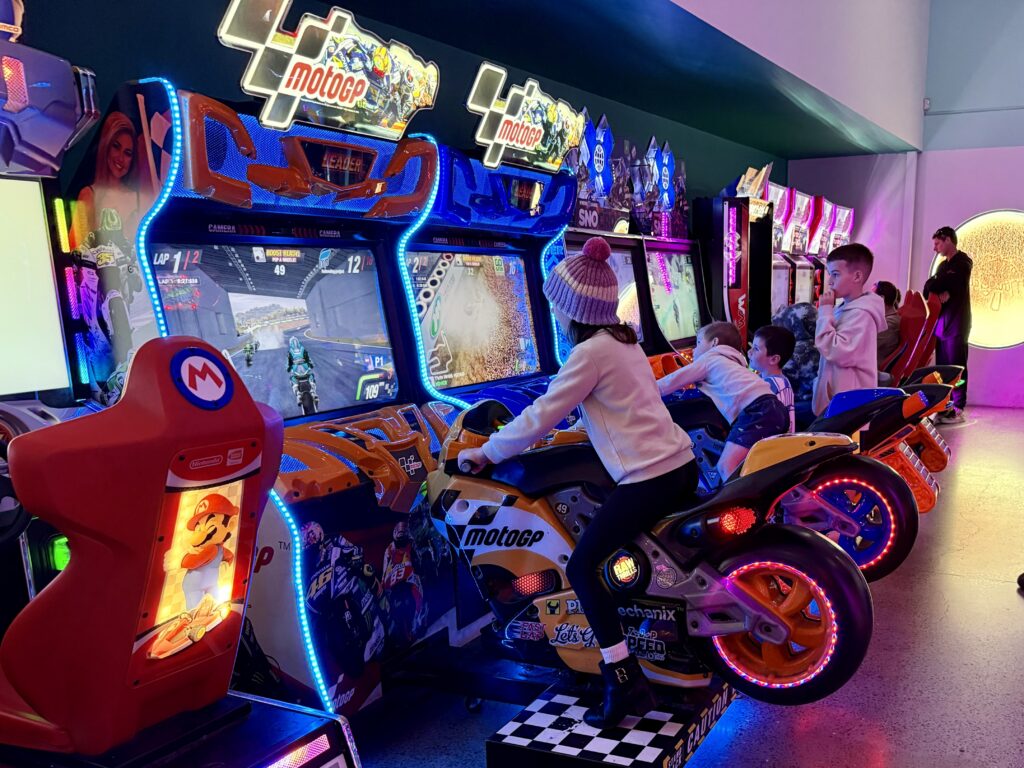 Kids racing on the arcade racing bikes on a rainy day