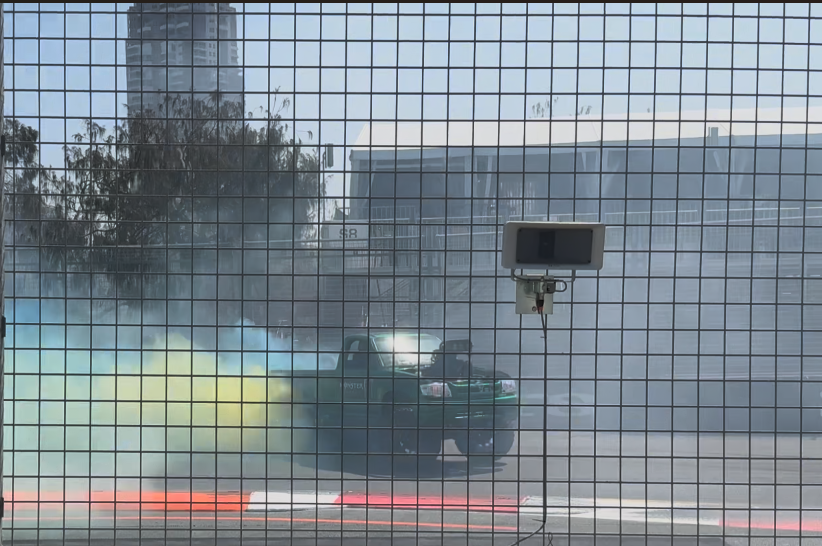 Truck burns up the track producing yellow and green smoke to entertain the crowds between races