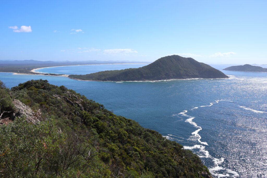 View from the lookout on Tomaree Headland looking across the entrance to Port Stephens towards Yacaaba Headland. Hawks Nest and Cabbage Tree Island can be seen in the distance.