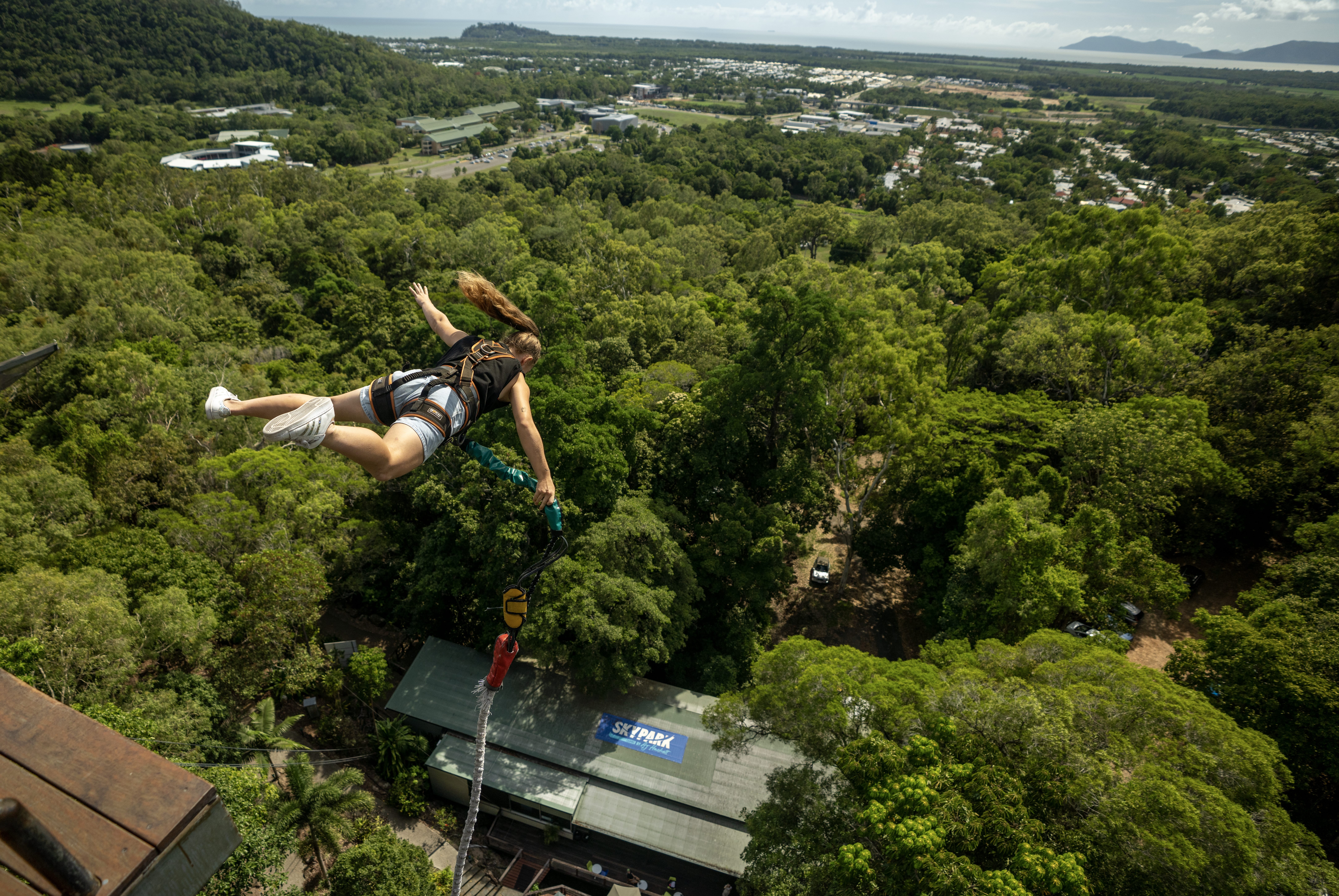 Girl plunges to the ground on a bungy jump at the Skypark Cairns by AJ Hackett in the rainforest