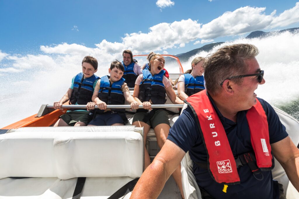Families holding on to the grab rails on the jetboat Bad Fishy in Cairns as it takes a hard turn