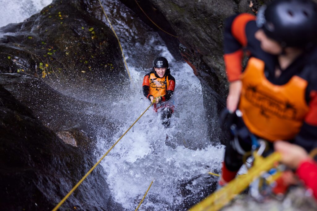 People abseiling down a waterfall on a canyoning adventure outside of Cairns.