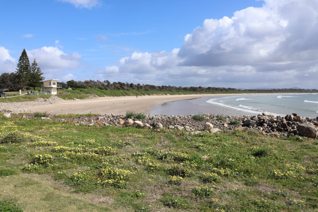 Waves gently roll into Crowdy Beach on a sunny day