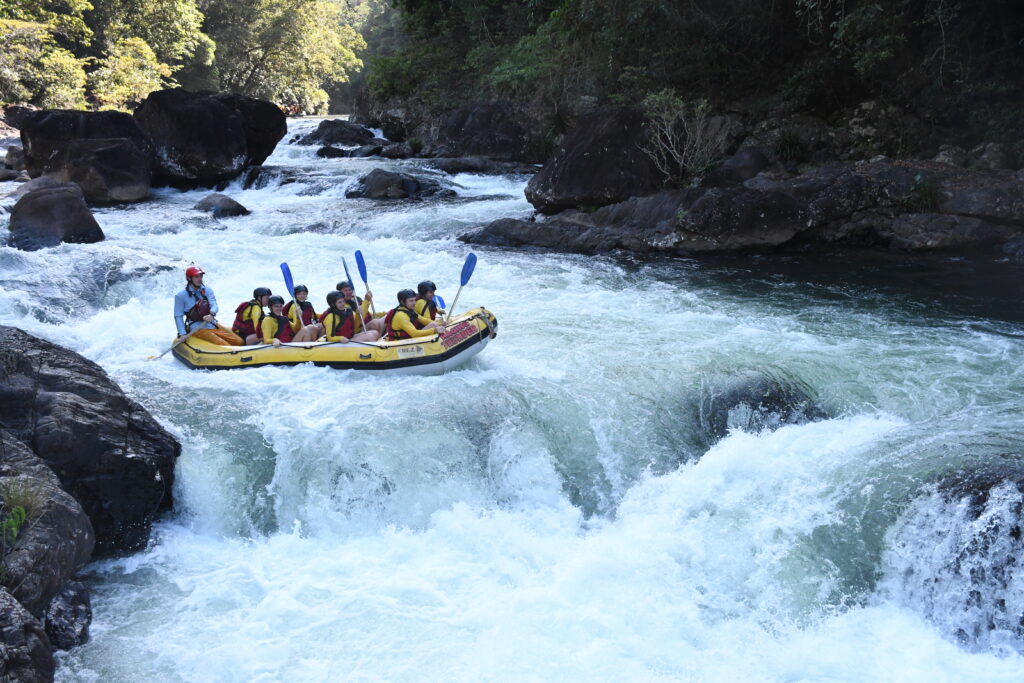 The yellow raft sits at the top of the rapid before dropping down showing the size of the rapids and gorge.