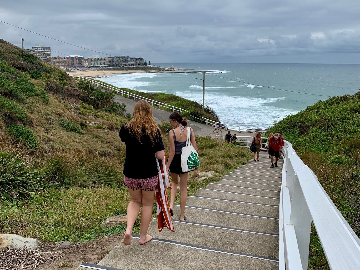 Stairs from King Edward Park Lookout leading down to the ocean pool, The Bogey Hole, Newcastle. Newcastle Beach and Newcastle city skyline in the distance.