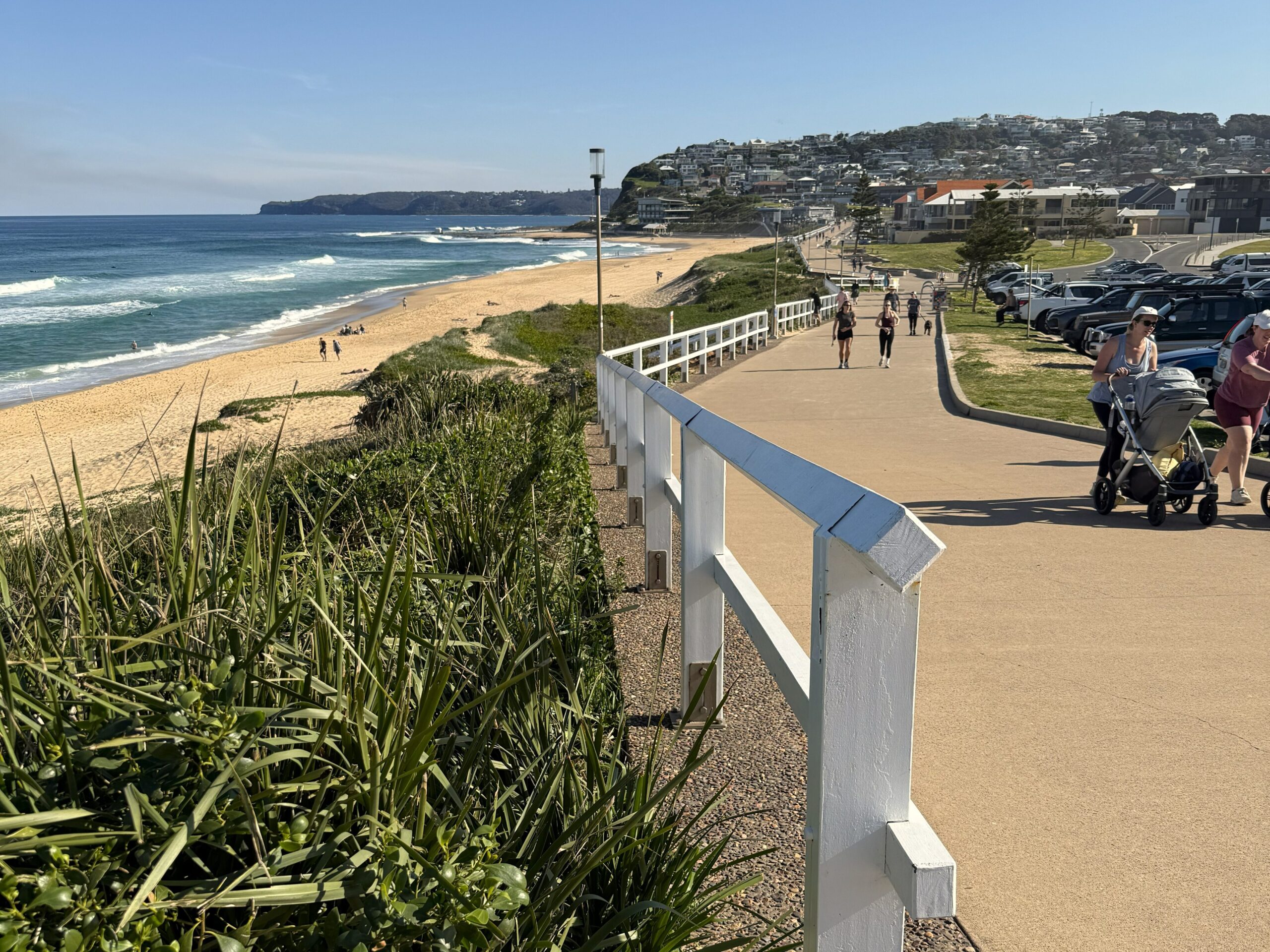 People enjoying a sunny day strolling along the Bather's Way alongside Merewether Beach