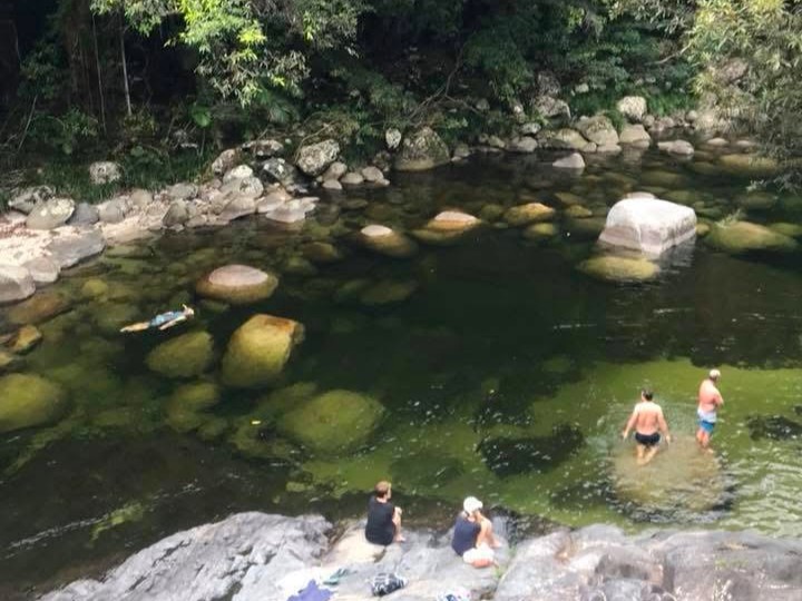 People going for a swim in the crystal clear fresh water with huge boulders in Mossman Gorge to escape the tropical heat.
