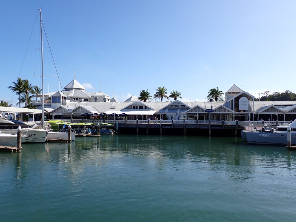 Crystalbrook Superyacht Marina in Port Douglas with its white timber work and white corrugated iron roof sparkles in the tropical sunshine.