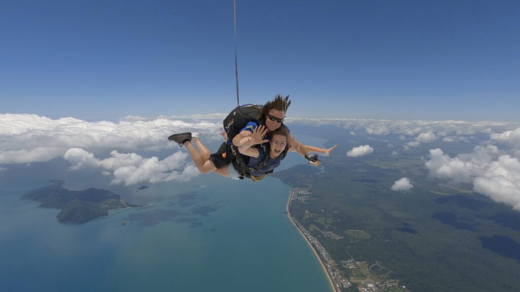 Tandem skydivers in free fall over Mission Beach
