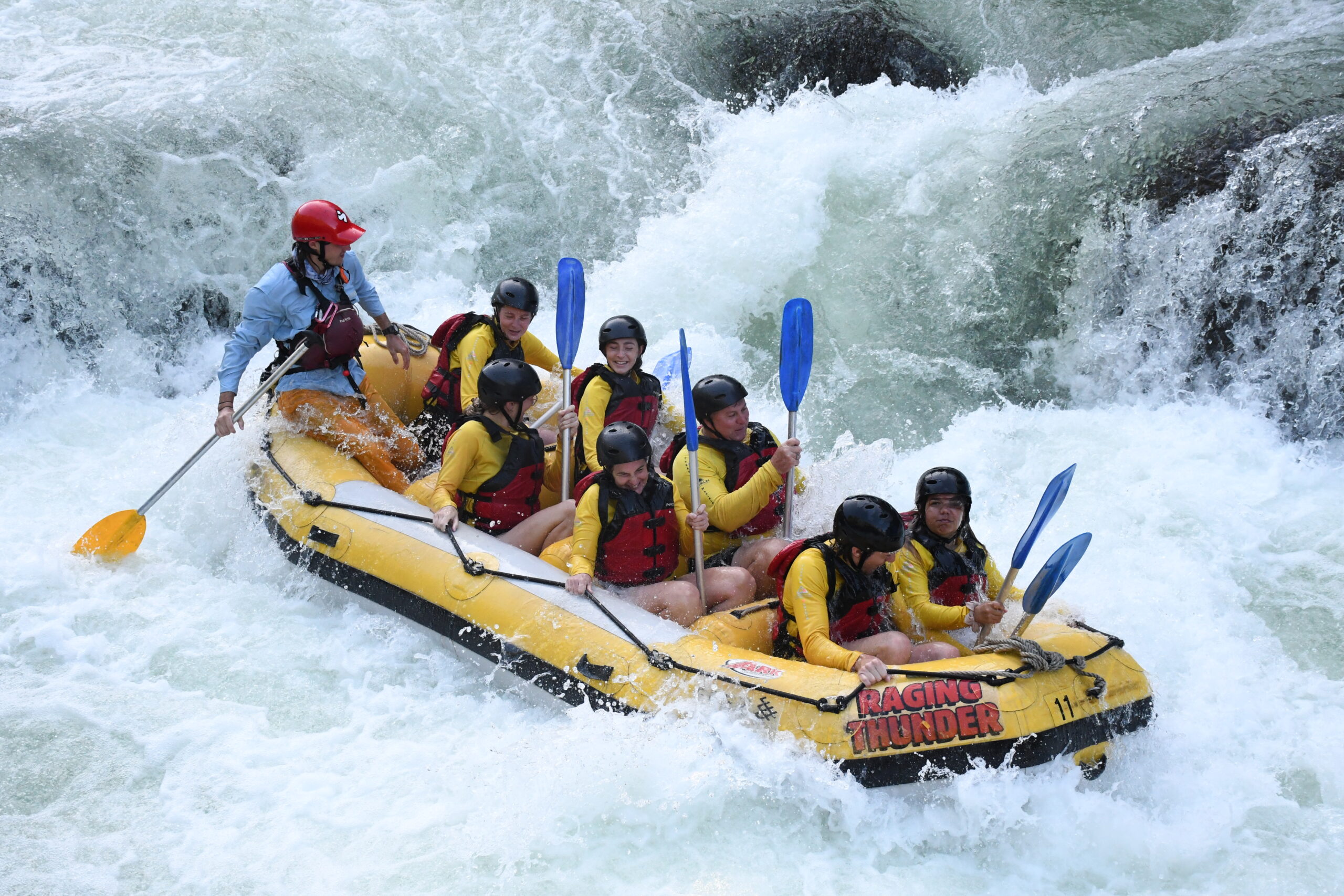 My family taking on Grade 4 rapids on the Tully River near Cairns in a large yellow inflatable raft.