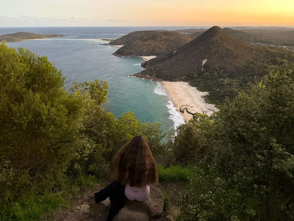 View from Tomaree Headland summit overlooking Zenith Beach and Fingal Spit as the sky turns orange at sunset