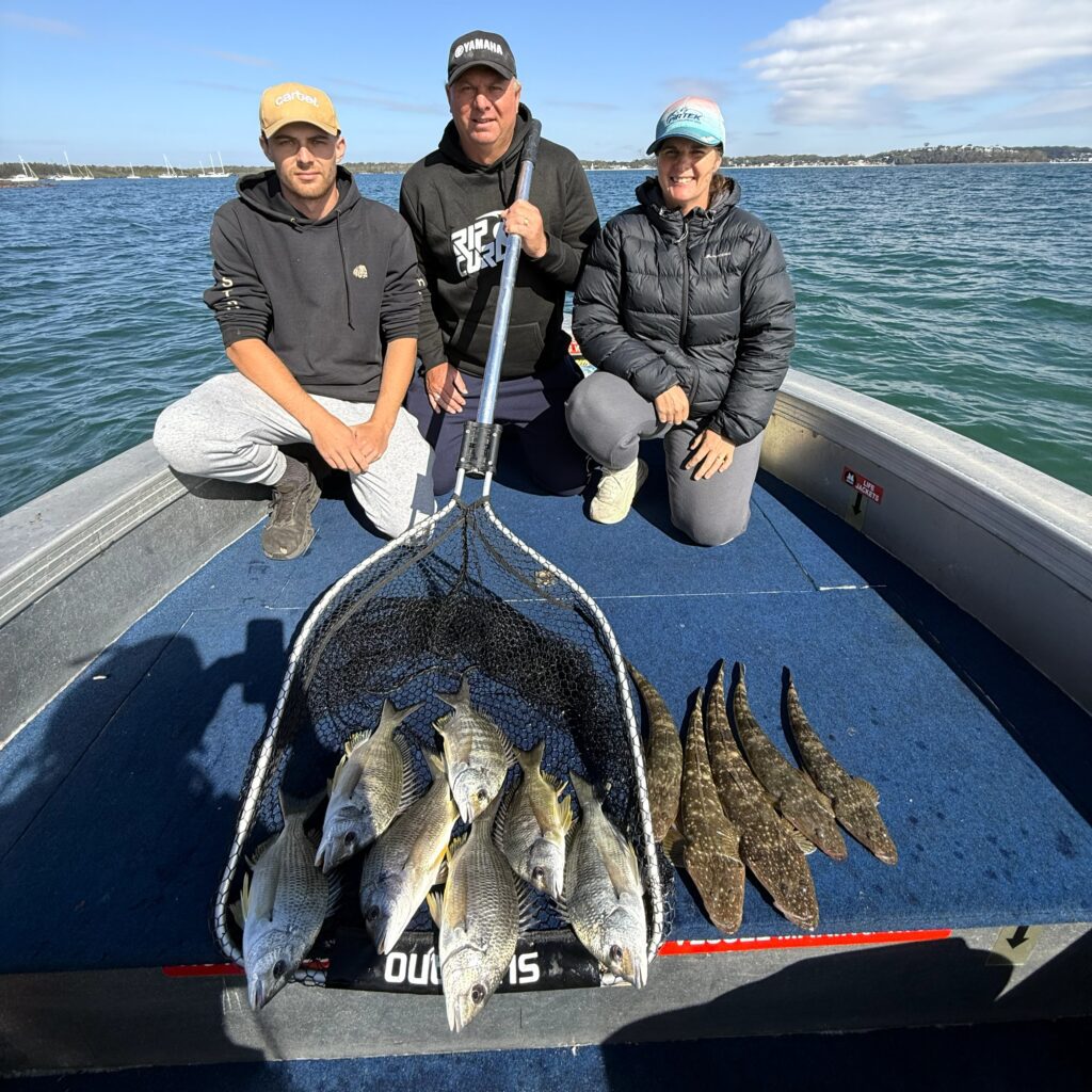 Family shows off their days catch of Bream and Flathead on a fishing trip with Port Stephens Estuary Fishing Charters.