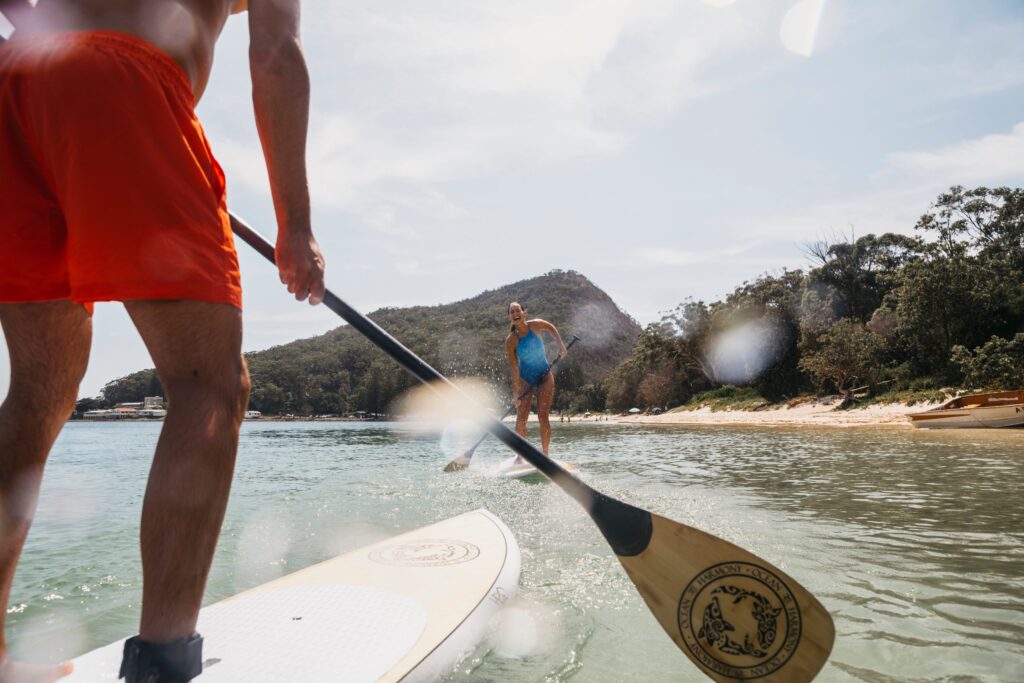 Friends enjoying the tranquil waters of Shoal Bay by SUP.
