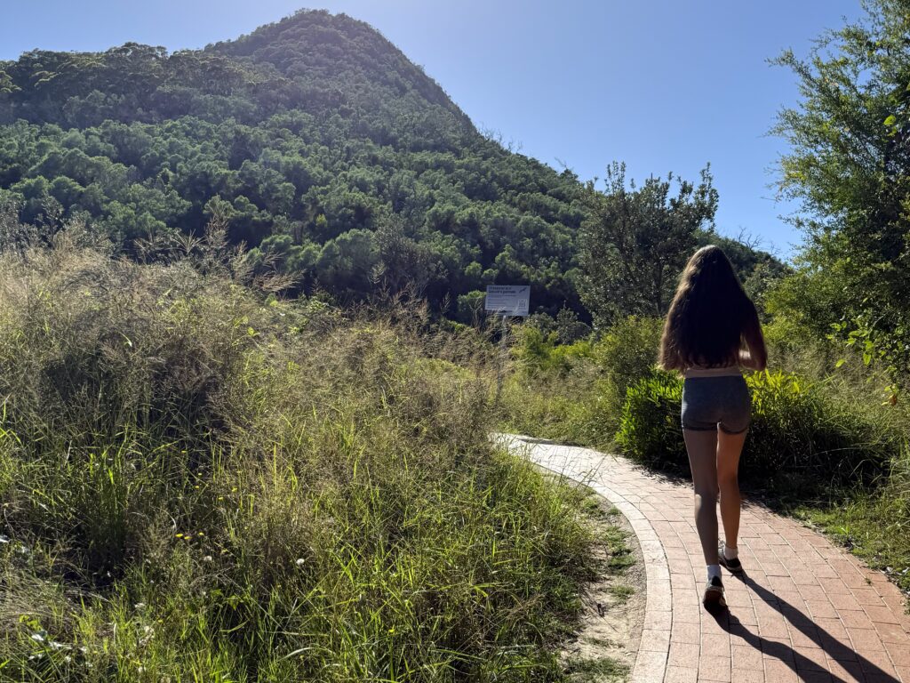 Girl walking up the red brick path to Tomaree Headland Summit